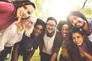 Un grup de studenți zâmbind la aparatul foto