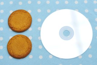 2 biscuiți cu nuci de ghimbir lângă un CD